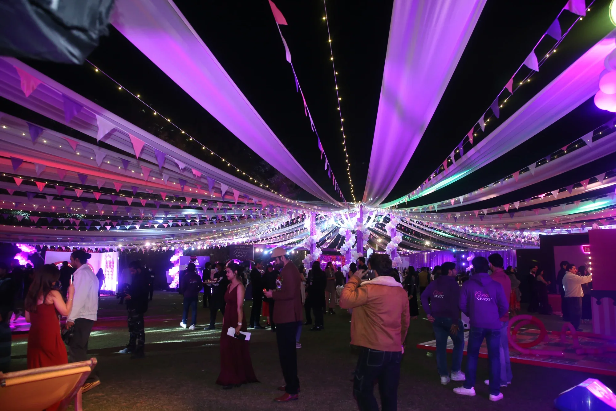 Prom night lawn glowing under a canopy of drapes, bunting and fairy lights